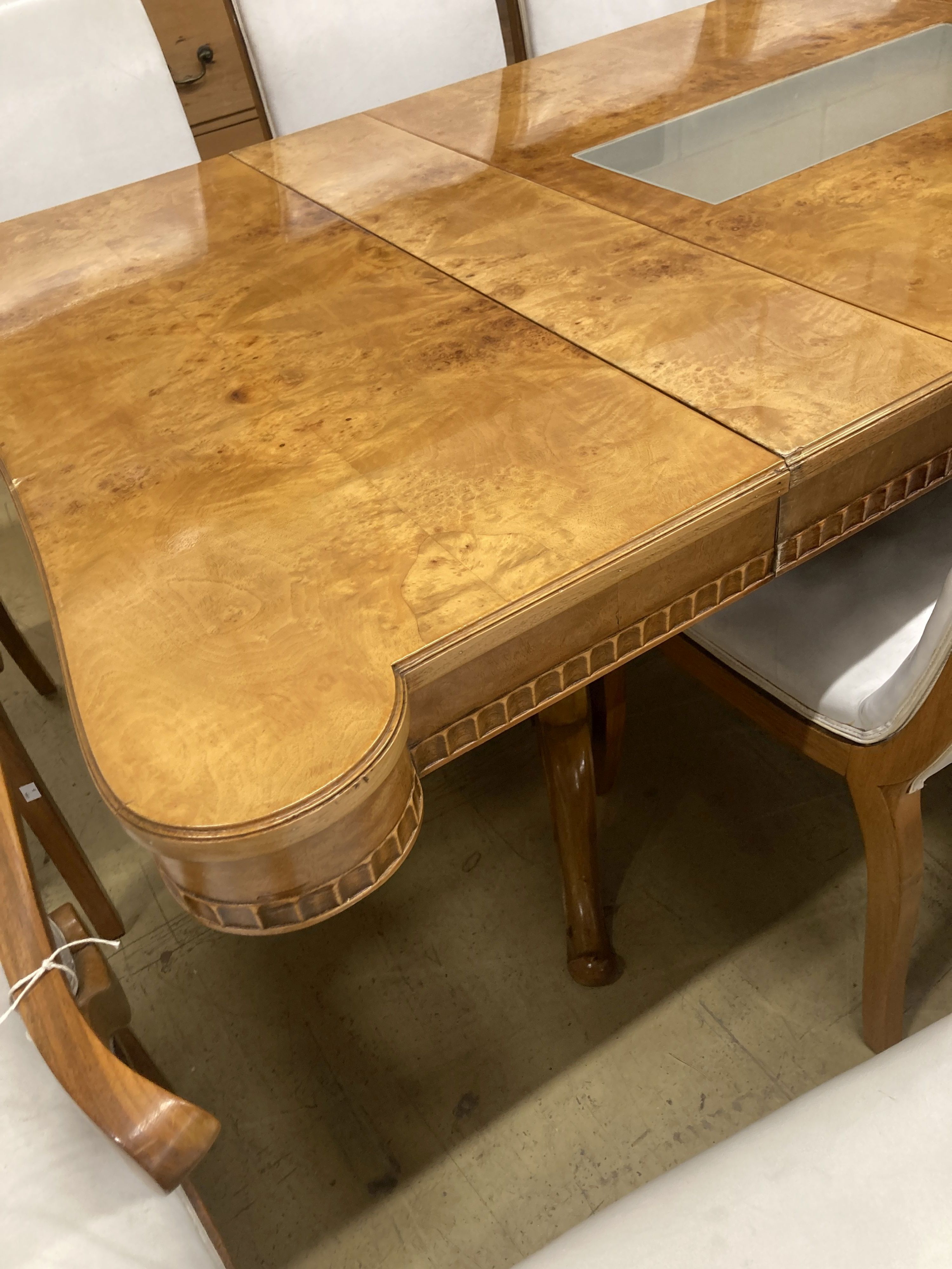 A mid century birds eye maple and walnut dining suite, comprising extending table, 205cm, depth 106cm, height 76cm, a set of ten dining